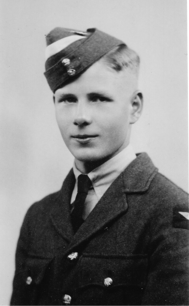 Studio portrait of E G White as a Leading Aircraftman in RAF uniform and forage cap bearing the white cap flash of aircrew under training, September 1941.